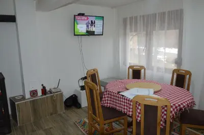 a room with a table and chairs with a table and a television at Planinska kuća Arbinje in Dojkinci
