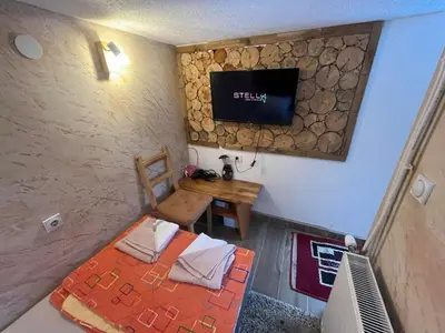 a room with a bed and a tv on a wall at Vlasinska Bajka in Vlasina Rid