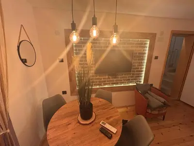 a dining room with a table and a television at Vlasinska Bajka in Vlasina Rid