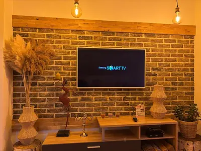 a living room with a brick wall with a flat screen tv at Vlasinska Bajka in Vlasina Rid