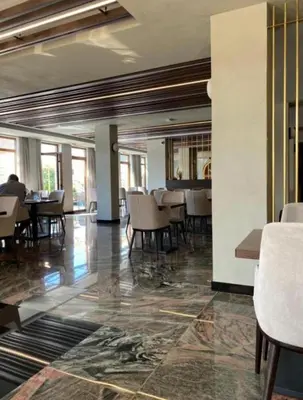 a dining room with tables and chairs in a building at Apolon Spa Lux in Vrnjačka Banja