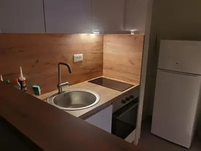 a small kitchen with a sink and a refrigerator at Apartman Karingtonka free parking in Vranje