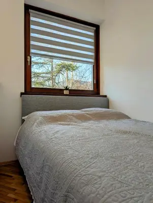 a bedroom with a bed in front of a window at Apartman Karingtonka free parking in Vranje