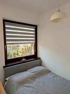 a bedroom with a window with a bed and a lamp at Apartman Karingtonka free parking in Vranje