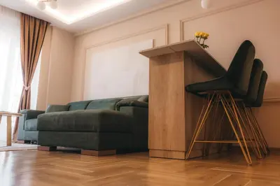 a living room with a green couch and a table at Apartman Mina - Vrnjačka Banja in Vrnjačka Banja