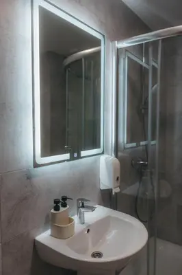 a bathroom sink with a mirror and a shower at Apartman Mina - Vrnjačka Banja in Vrnjačka Banja