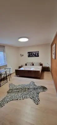 a room with a bed and a leopard print rug at Plavi Dom in Ćuprija
