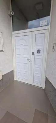 a garage with a white door in a room at Plavi Dom in Ćuprija