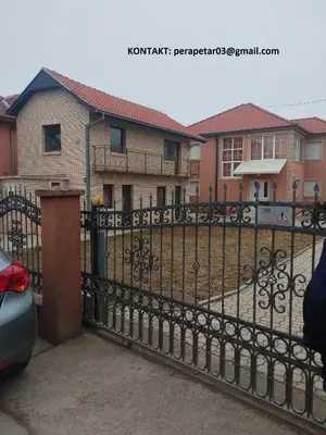 a black iron fence in front of a house at AK House in Niš