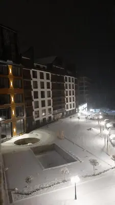 a parking lot with snow on the ground and buildings at Tontic Lux Residence Hill 54 in Kopaonik
