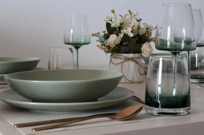 a table with a bowl and plates and glasses on it at Apartman TAUNUS in Kopaonik