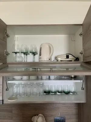 a shelf with glasses and other items on it at Apartman TAUNUS in Kopaonik