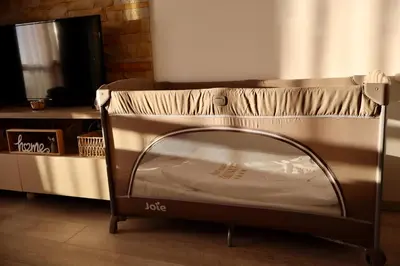 a small bed in a room next to a tv at Apartman TAUNUS in Kopaonik