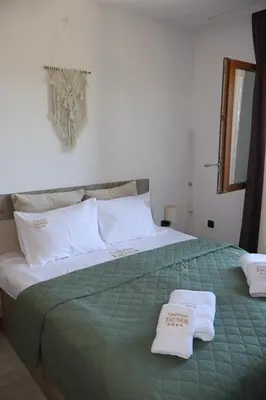 a bedroom with a large bed with two towels on it at Apartman TAUNUS in Kopaonik