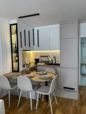 a kitchen with a wooden table and chairs in a room at Zlatkovic Family in Pirot