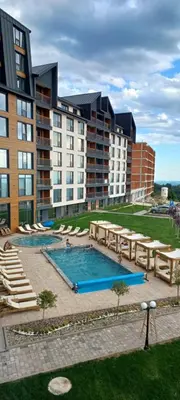 a hotel with a pool and some chairs and buildings at Residence Hill apartment TammyMatty in Kopaonik