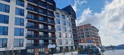 a tall building with cars parked in front of it at Residence Hill apartment TammyMatty in Kopaonik