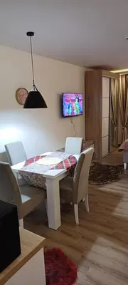 a living room with a table and chairs and a tv at Residence Hill apartment TammyMatty in Kopaonik