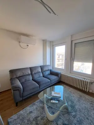 a living room with a couch and a glass table at Apartman Tea in Niš