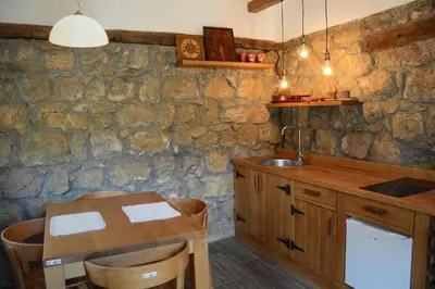a kitchen with a wooden table and a sink at Serbina in Kandalica
