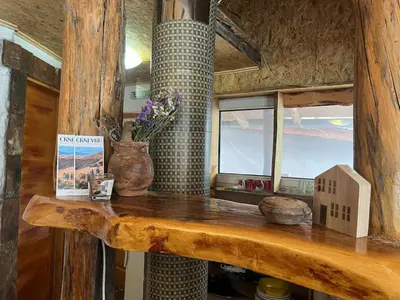a wooden table with a vase and flowers on it at Apartmani Manojlović in Crni Vrh