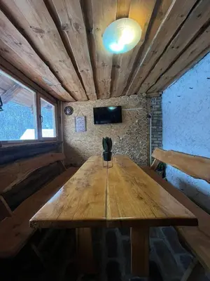 a large wooden table in a room with a tv at Apartmani Manojlović in Crni Vrh