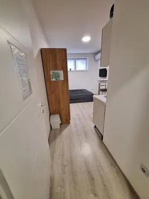 a room with a hallway with a door and a kitchen at Apartman-studio Sokobanja in Soko Banja