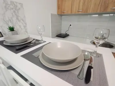 a table with two plates and glasses on a kitchen counter at Apartman-studio Sokobanja in Soko Banja