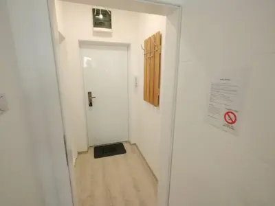 a hallway with a door and a sign on a wall at Apartman-studio Sokobanja in Soko Banja