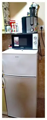 a coffee maker sitting on top of a refrigerator at Origami in Niš