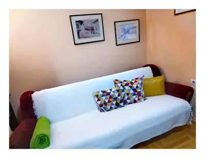 a white couch with pillows on it in a room at Origami in Niš