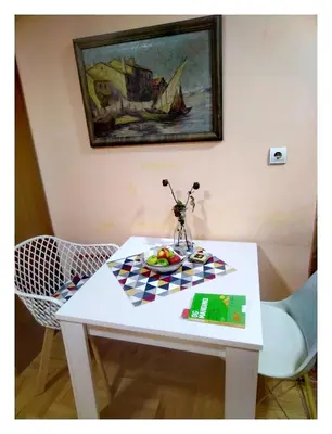 a white table with a plate of fruit on it at Origami in Niš