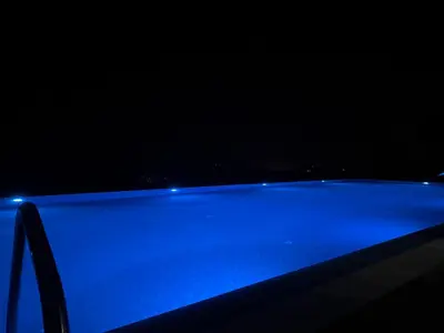 a blue swimming pool in a dark room at Gold Elegant & Spa Kop in Kopaonik