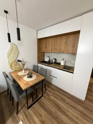 a kitchen and dining room with a wooden table and chairs at Gold Elegant & Spa Kop in Kopaonik