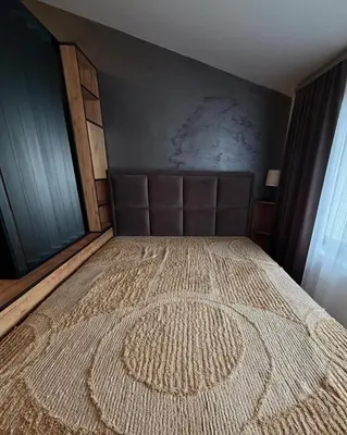 a bedroom with a large bed with a rug on it at Apartmani Mir Kopaonik in Kopaonik