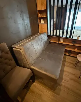 a leather couch sitting in a living room with a window at Apartmani Mir Kopaonik in Kopaonik