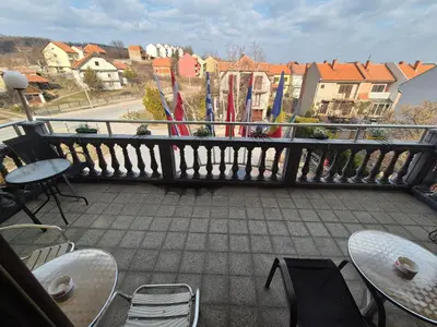 a balcony with tables and chairs and a railing with flags at Vila Vienna in Zaječar