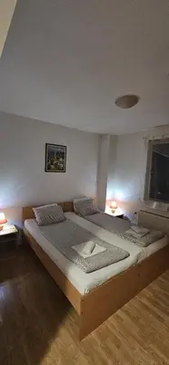 a large bed in a room with two lamps at Vila Vienna in Zaječar