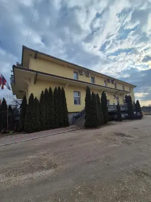 a building with a row of trees in front of it at Vila Vienna in Zaječar