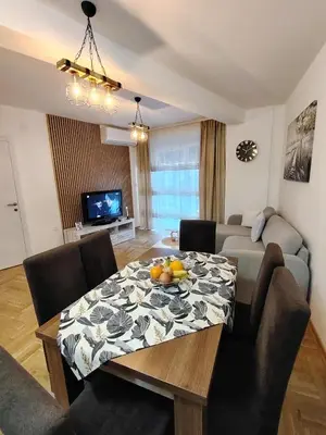 a living room with a table and a couch at Apartman Bonbon in Vrnjačka Banja