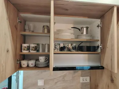 a cupboard with plates and dishes in it at Apartman Bonbon in Vrnjačka Banja