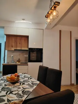 a kitchen with a table with a bowl of fruit on it at Apartman Bonbon in Vrnjačka Banja