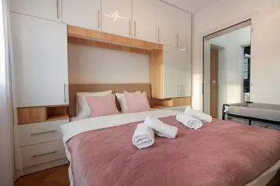 a bedroom with a large bed with towels on it at Apartman Babić Lux in Vrnjačka Banja