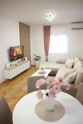 a living room with a couch and a table with flowers at Apartman Babić Lux in Vrnjačka Banja