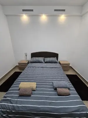 a bedroom with a large bed with two pillows on it at Best apartments 2 in Paraćin