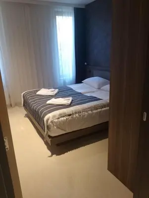 a bedroom with a bed with two towels on it at WOODside 70m2 Kopaonik in Kopaonik