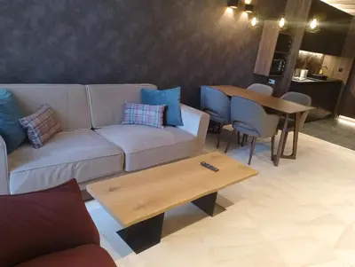 a living room with a couch and a table at WOODside 70m2 Kopaonik in Kopaonik