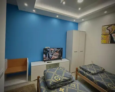 a room with two beds and a blue wall at 