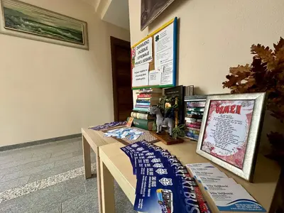 two tables in a room with books on the wall at 