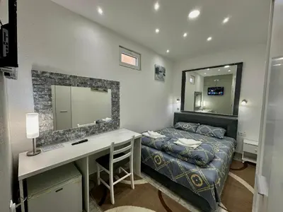 a bedroom with a bed and a desk and a mirror at 